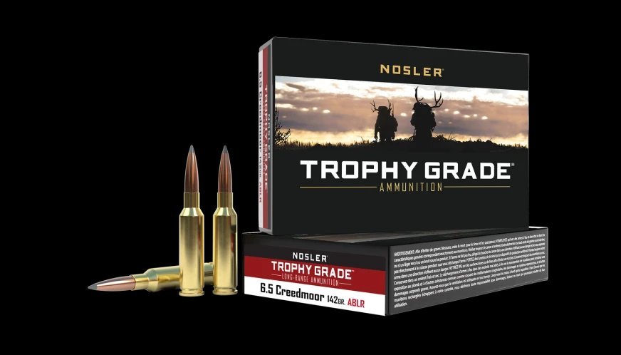 Nosler Trophy Grade Long Range 6.5 Creedmoor 142 grain ABLR ammunition 20-round box featuring mountain sunset landscape artwork and loose cartridges