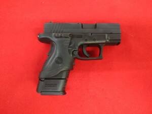Used Springfield XD Subcompact Pistol 9mm with Crimson Trace laser grip on red background
