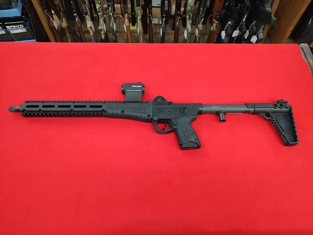 Used Kel-Tec SUB-2000 Rifle 9mm with Holosun red dot sight on red background