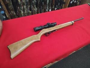 Used Ruger 1022 Rifle 22 LR with wood stock and Pursuit scope on red table