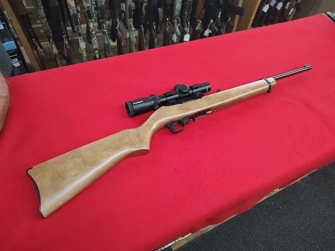 Used Ruger 1022 Rifle 22 LR with wood stock and Pursuit scope on red table