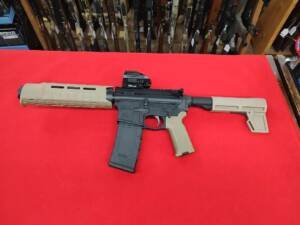 Used PSA PA-15 300 Blackout pistol with FDE Magpul furniture and red dot on red background