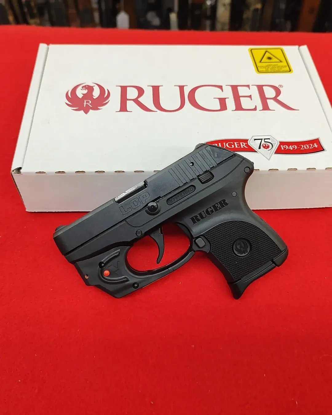 Ruger LCP 380 Pistol with Viridian E-Series red laser in front of factory box