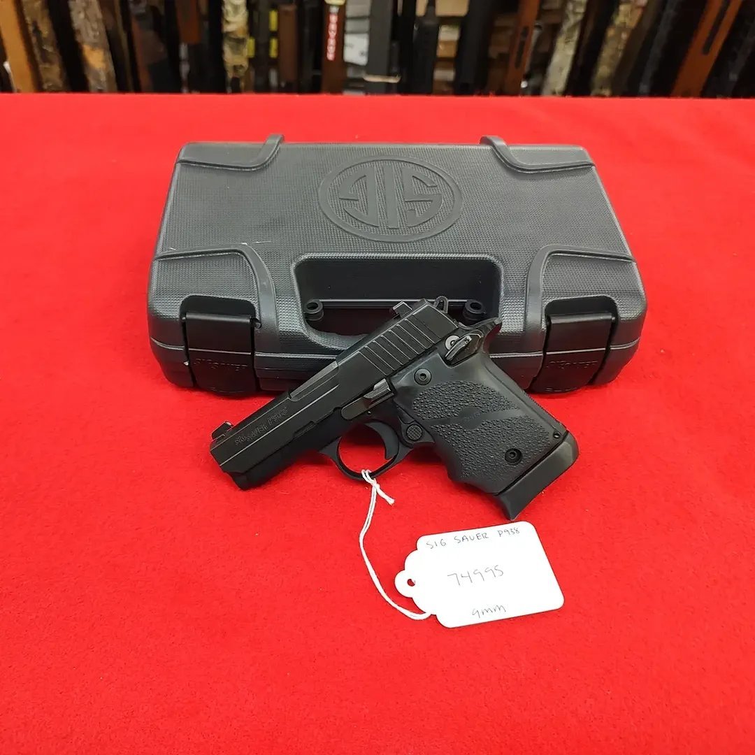 Sig Sauer P938 Rubber Grip 9mm handgun resting in front of factory case
